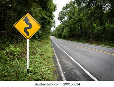 Curvy Road Sign To The Mountain In Rural Area