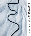 Curvy windy road in snow covered mountain hill. Top down aerial view.  Scenic winter background captured from above. Travel concept. Passo Di Giau,Dolomities,Italy.