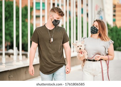 Curvy Woman And Handsome Man Wearing Face Mask Taking A Walk With Their Dog - Coronavirus Concept