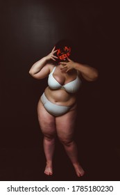 Curvy woman wearing demon mask. Fine art concept