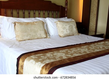 Cushions And Dressed Bed Linen On The Bed In The Hotel