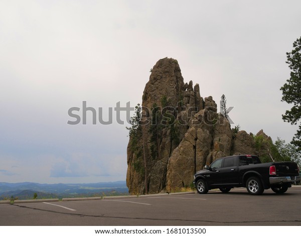 Custer State Park, South Dakota-\
July 2018: A pickup truck parks infront of a beautiful rock\
formation at Needles Highway, Custer State Park, South Dakota.\
