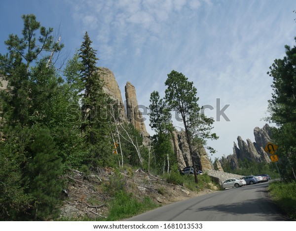 Custer State\
Park, South Dakota- July 2018: Cars parked on the roadside at the\
Cathedral Spires at Needles\
Highway.