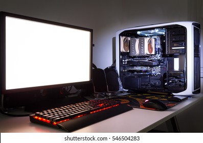 Custom Built Gaming Computer With White Screen, Keyboard, Mouse, Desktop, Components, Hardware, Gaming Chair Under Low Light. Selective Focus.