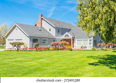 Custom Built Luxury Farm House With Nicely Trimmed And Designed Front Yard, Tulips, Lawn In A Residential Neighborhood In Canada. Large Family House.