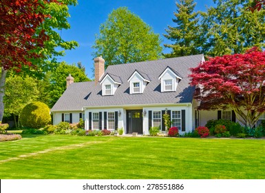 Custom built luxury house with nicely trimmed and decorated front yard, lawn in a residential neighborhood. Vancouver Canada.