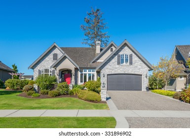 Custom built luxury house with nicely trimmed front yard, lawn and long doorway and driveway in a residential neighborhood. Vancouver Canada.