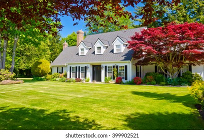 Custom built luxury house with nicely trimmed and landscaped front yard, lawn in a residential neighborhood. Vancouver Canada.