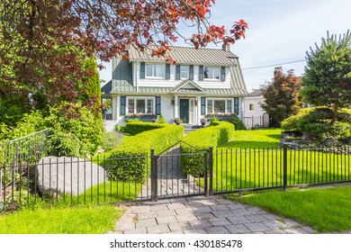 Custom built luxury house with nicely trimmed and designed front yard, lawn in a residential neighbourhood in Canada. - Shutterstock ID 430185478