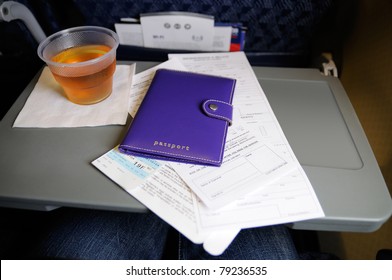 Custom Forms And Passport On The Seat Tray Aboard An Airline Flight