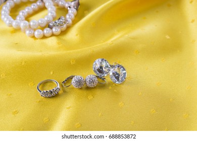 Custom Jewelry Like Earrings And Ring On The Yellow Background