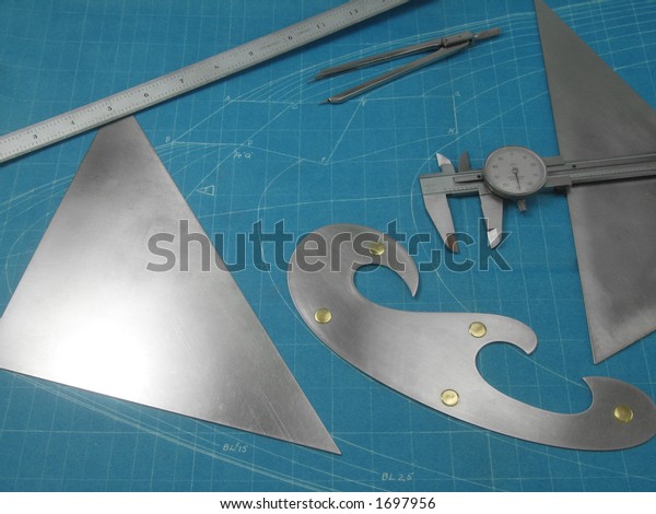 Custom\
machined, stainless steel drawing tools on a blueprint background.\
The blueprint is a training drawing of the nose contour of a large\
jet, no copyright, and over 50 years\
old.