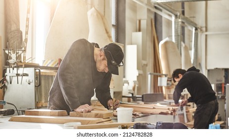 Custom projects with artistic, design oriented value. Portrait of caucasian worker holding a brush, applying varnish paint on a wooden furniture - Powered by Shutterstock