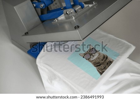 Custom t-shirt. Using heat press to print photo of cute cat in sunglasses