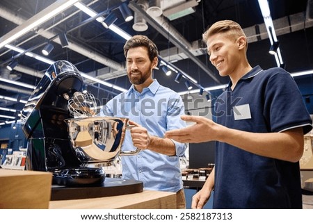 A customer actively engages in conversation with a knowledgeable sales associate, discovering the features and benefits of a premium stand mixer while surrounded by a lively retail atmosphere