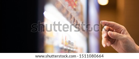 A customer buying beverage at a vending machine