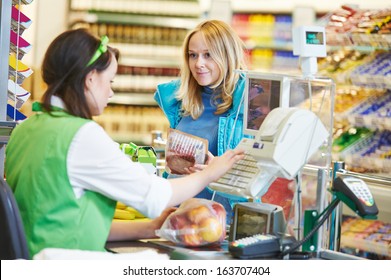 Customer Buying Food At Supermarket And Making Check Out With Cashdesk Worker In Store