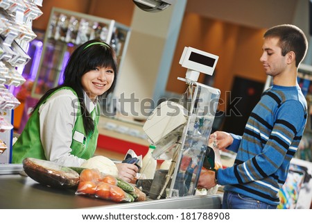 Customer buying food at supermarket and making check out with cashdesk worker in store