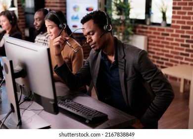 Customer care service assistant working at call center, helping clients on telephone helpline. Telemarketing operator answering call from people to give remote assistance at helpdesk.