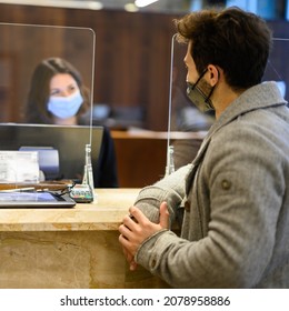 Customer Checking In At A Hotel Reception Wearing Masks To Protect From Covid 19 Coronavirus Pandemic