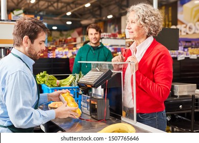 Customer At Checkout In Supermarket Looks At Cashier At Work