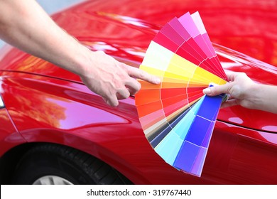Customer Choosing Color Over Red Car Background