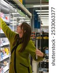 Customer choosing frozen food products from a refrigerated aisle at the grocery store