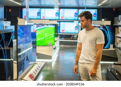 Customer Choosing Modern TV Set In Shop