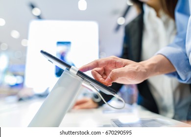 Customer Choosing A New Mobile Phone In A Shop