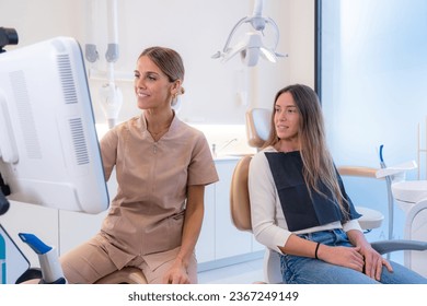 Customer and dentist looking at the results in a screen in a modern dental clinic - Shutterstock ID 2367249149