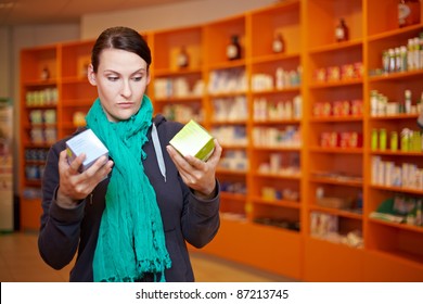 Customer Doing A Price Comparison In A Pharmacy