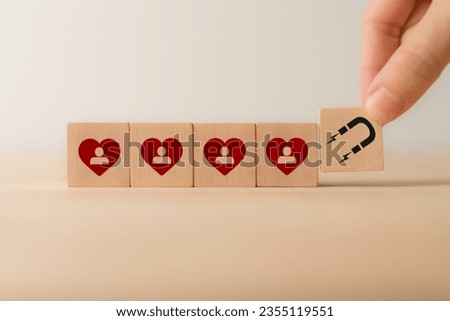 Customer engagement, increasing customer loyalty concept. Building relationships, increase brand awareness, and drive sales. Wooden cube blocks with red hearts and customer loyalty icon on background.