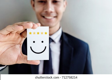 Customer Experience Concept, Happy Businessman Holding Card With Smiley Face And Five Star Rating For His Satisfaction