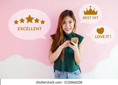 Customer Experience Concept. Happy Young Woman Using Smart Phone To Review And Feedback Rating In Online Satisfaction Survey Application. Looking At Camera With Smile