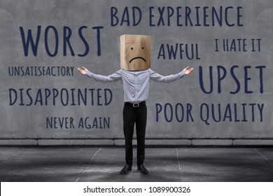 Customer Experience Concept, Unhappy Businessman Client with Sadness Emotion Face on Paper Bag, Blurred Concrete Wall with Wording of Negative Reviews as background