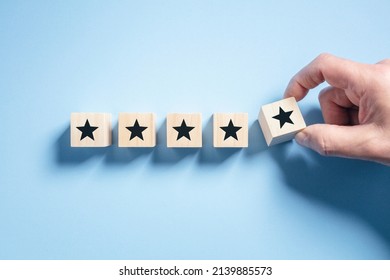 Customer experience feedback rate satisfaction experience five star rating placing wooden blocks on blue background
