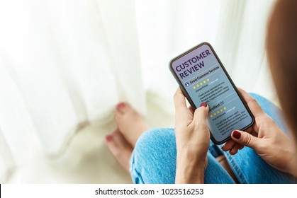 Customer Experience and Online Review Concept. Female sitting in house to Reading Customer Review in SmartPhone before Buying Products. Top view