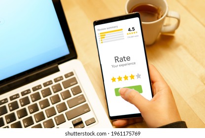 Customer Experience Ratings Concept. Hand Of A Woman Using A Smartphone To Submit Stars Feedback, And Review To Products Or Services She Quite Satisfied. Marketing Business Important Tools. Surveys.