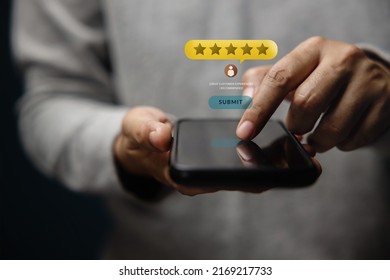 Customer Experiences Concept. Happy Client Using Smartphone To Submit Five Star Review Rating For Online Satisfaction Surveys. Positive Feedback On Mobile Phone