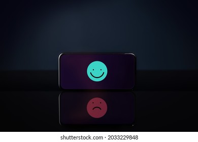 Customer Experiences Or Mental Health Concept. Smiling Cartoon On Mobile Phone Reflect A Sadness Face. Feedback On Smartphone. Positive And Negative Review. Online Satisfaction Survey