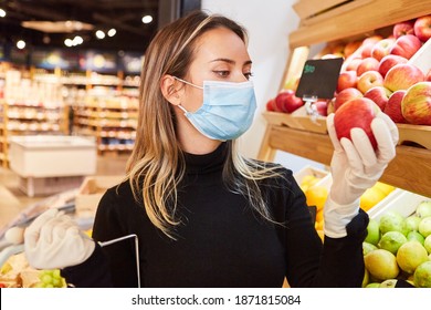 Customer With Face Mask Because Of Covid-19 Pandemic While Shopping For Fruit With An Apple