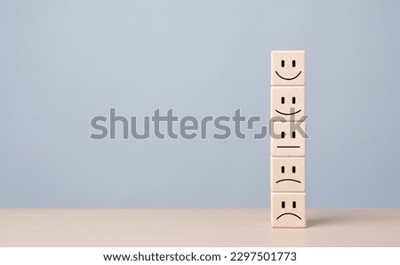 Customer feedback rating positive or negative review, Human health and wellness check. World mental health day, Think Positive and Satisfaction survey concept. Wooden cubes stacked with emotion icons.