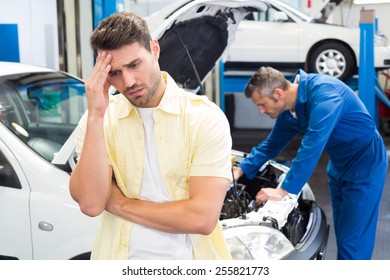 Customer feeling worried about his car at the repair garage - Powered by Shutterstock