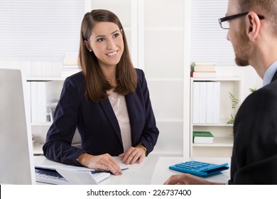 Customer and female financial agent in a discussion at desk. - Powered by Shutterstock