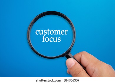 Customer Focus, Business Concepts. Hand Holding Magnifying Glass Focusing On The Words.