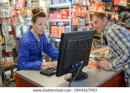 Customer glancing at shop keeper's computer