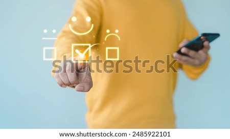 Customer hand touch a virtual screen showing a happy smile icon, indicating service satisfaction. Business concept involves assessment, customer service testimonials, and feedback, rated very good.