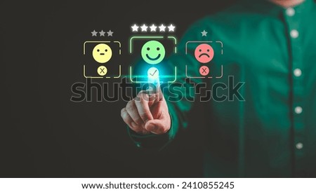Customer hand touching the virtual screen on happy smile face icon to give satisfaction in service. Concept of assessment testimonial customer service and feedback, Opinion rating very impressed.