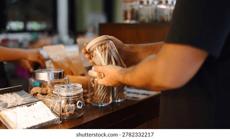 Customer hands selecting pre rolled cannabis joints in a modern dispensary shop