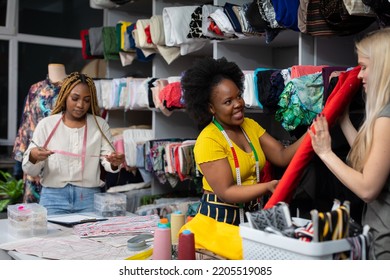 The customer, with the help of a dark-skinned expeditor, selects the fabric for the dress.
